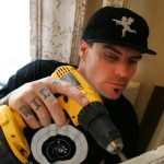 A man holding a drill and a circular saw.